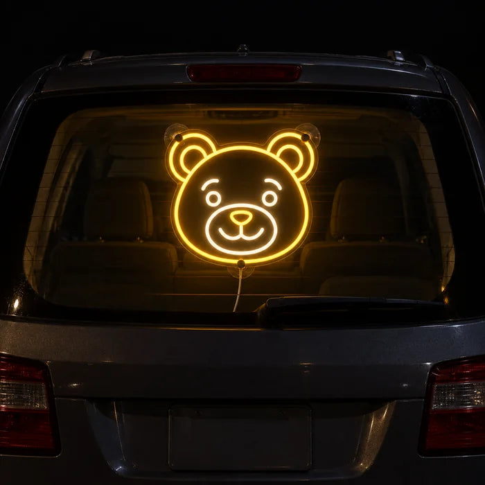 Bärenlächeln Neon LED Schild an der Heckscheibe eines Autos bei Nacht