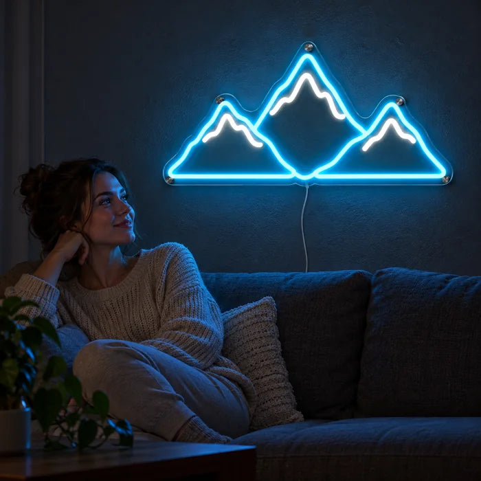 Bergsilhouette Neon LED Schild an der Wohnzimmerwand, davor entspannt eine Person auf dem Sofa