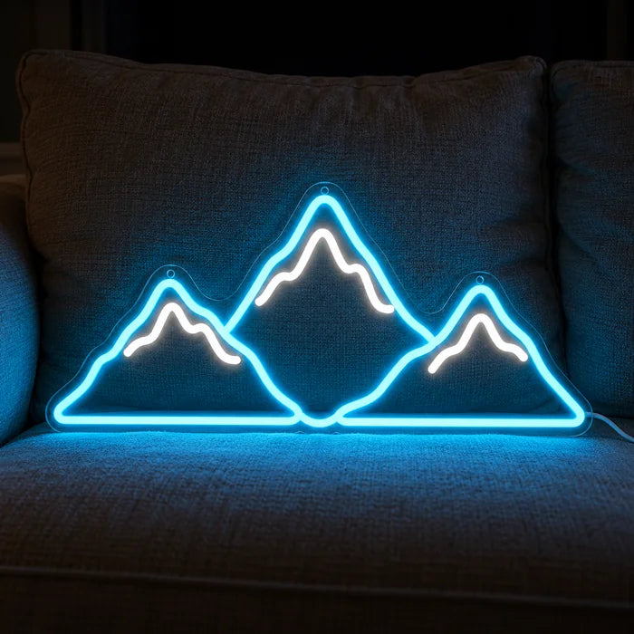 Bergsilhouette Neon LED Schild auf einem gemütlichen Sofa zwischen Kissen und Decke