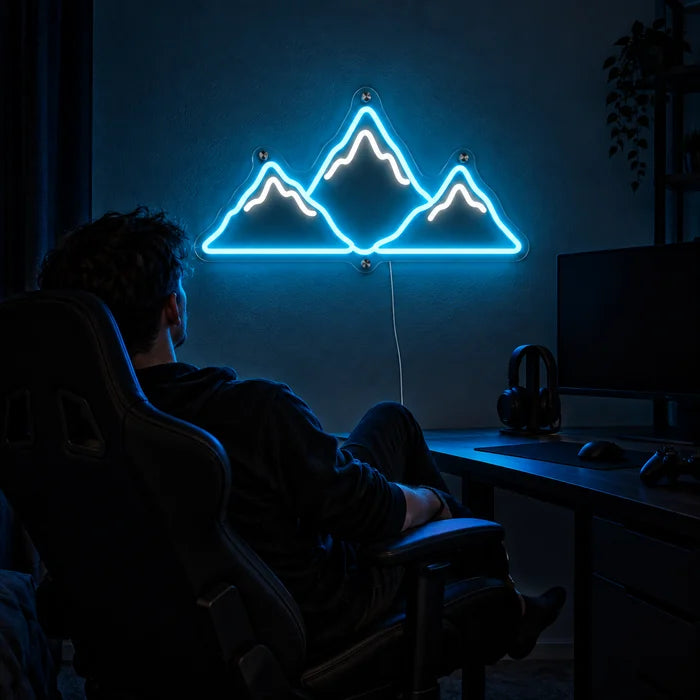 Bergsilhouette Neon LED Schild über dem Gaming-Schreibtisch, davor ein Spieler im Gaming-Stuhl