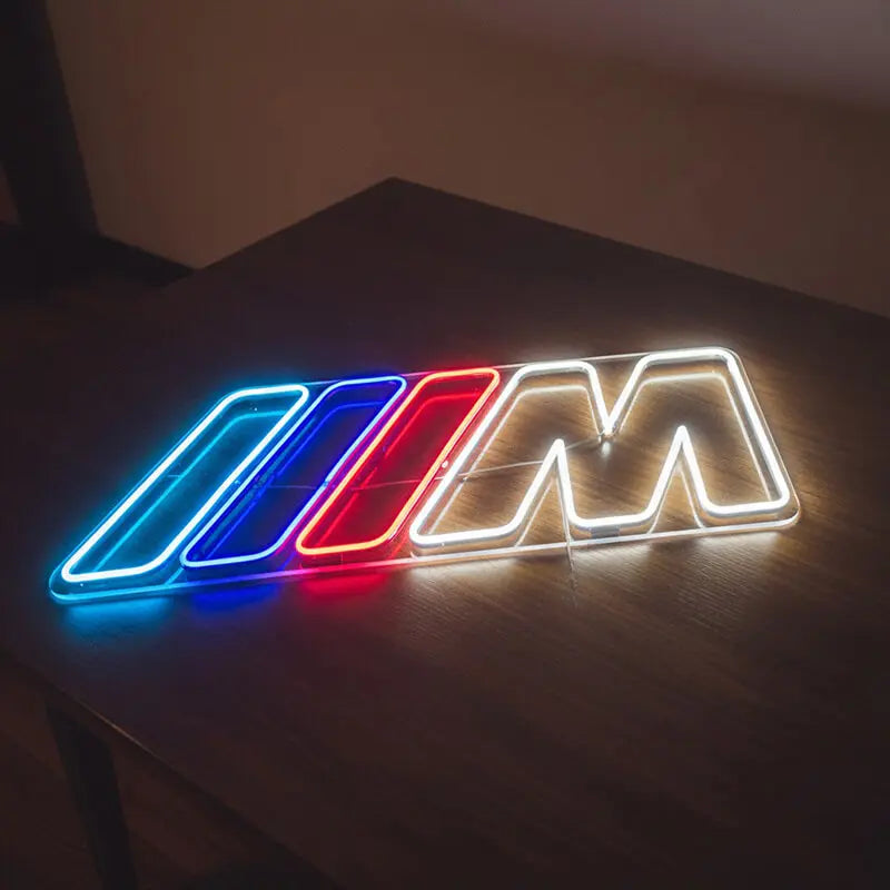 Stylisches LED-Neonschild des BMW M Logos, das eine Wand in Blau, Rot und Weiß beleuchtet, perfekt für eine Garage oder ein Gaming-Zimmer