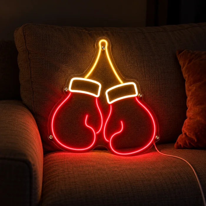 Boxhandschuhe Neon LED Schild auf einem gemütlichen Sofa zwischen Kissen und Decke