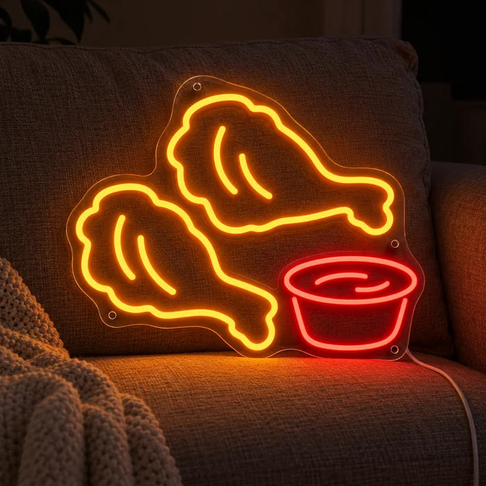 Chicken Nuggets Neon LED Schild auf einem gemütlichen Sofa zwischen Kissen und Decke