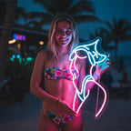 Custom-Neon-Sign einer weiblichen Figur mit hochgezogenen Armen, beleuchtet in Pink als moderne Wanddeko.

