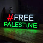 Acryl-LED-Schild mit den Worten FREE PALESTINE, wobei die erste Zeile weiß und die zweite grün ist.
