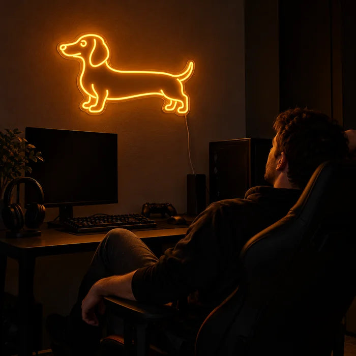 Dackel Neon LED Schild über dem Gaming-Schreibtisch, davor ein Spieler im Gaming-Stuhl