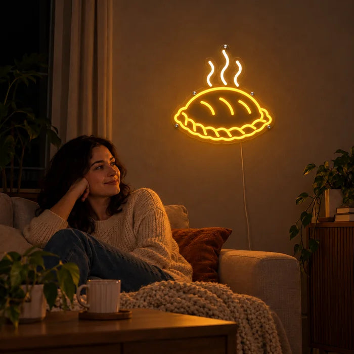 Dampfende Teigtasche Neon LED Schild an der Wohnzimmerwand, davor entspannt eine Person auf dem Sofa