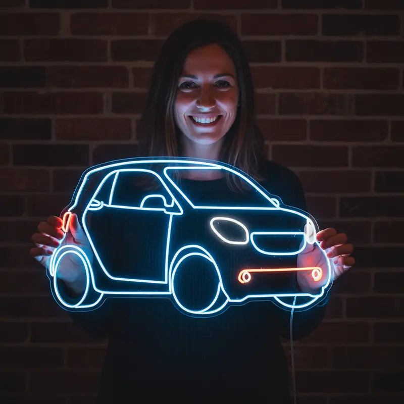 Stylisches Deko-Neon-Licht, das den Umriss eines Smart Fortwo darstellt. Die Hauptfarbe ist Blau, die Frontlichter sind orange