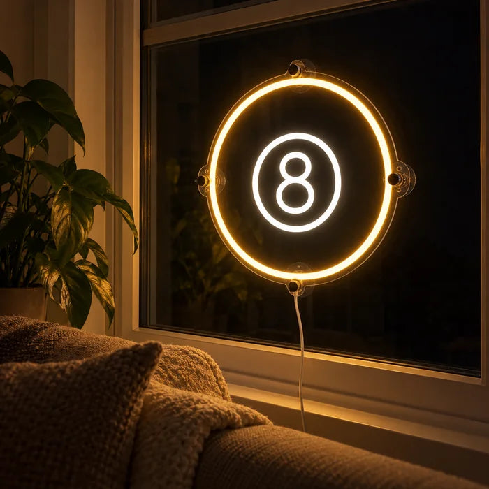 Die schwarze Acht Neon LED Schild abends im Fenster eines gemütlichen Wohnzimmers
