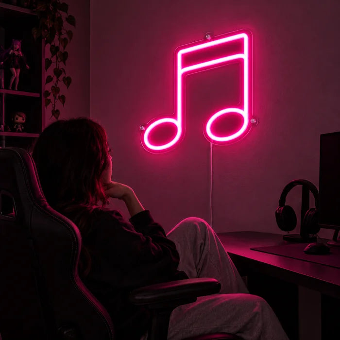 Doppelnote Neon LED Schild über dem Gaming-Schreibtisch, davor ein Spieler im Gaming-Stuhl