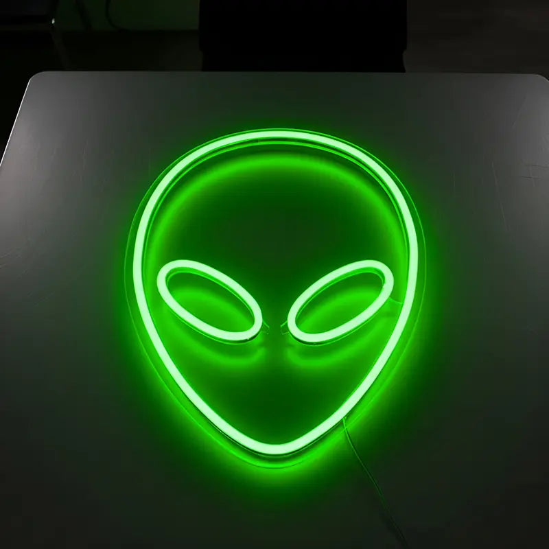 Deko-Leuchtschild mit dem Alien-Kopf als grünes Neon-Symbol für Gaming-Zimmer oder Bars.
