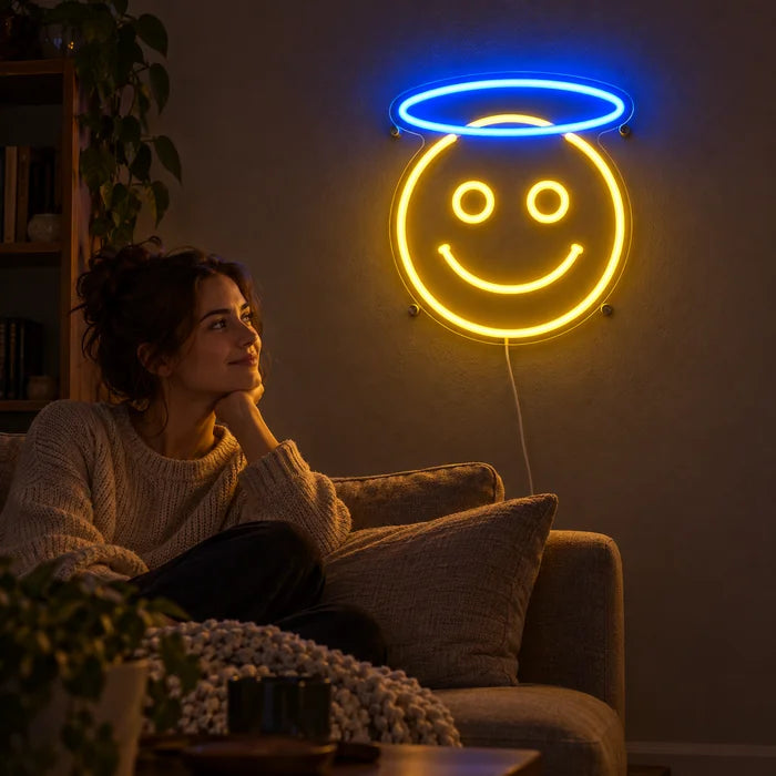 Engel-Smiley Neon LED Schild an der Wohnzimmerwand, davor entspannt eine Person auf dem Sofa