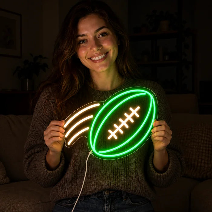 Football im Flug Neon LED Schild in den Händen einer lächelnden Frau vor dunklem Hintergrund