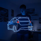 Nahaufnahme eines LED-Neon-Schildes mit der Silhouette eines Ford Focus, inklusive markantem Dachspoiler und sportlichen Auspuffrohren.