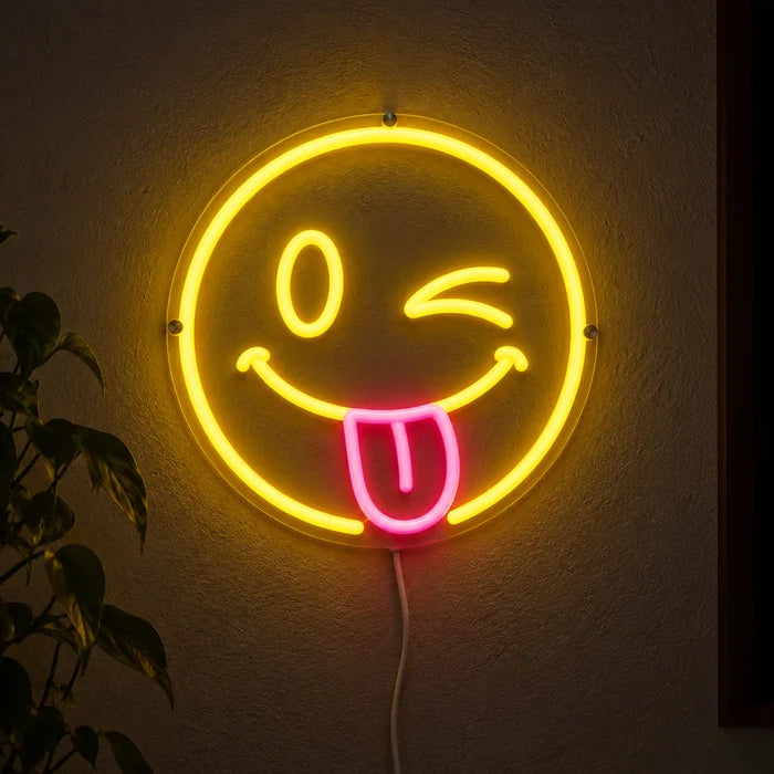 Frecher Smiley Neon LED Schild leuchtend an einer dunklen Wand, Nahaufnahme mit Anschlusskabel