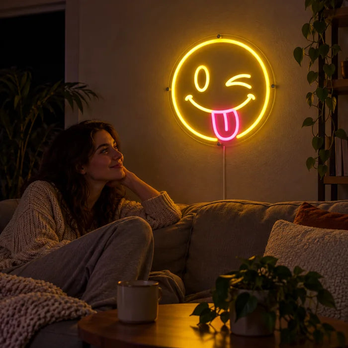 Frecher Smiley Neon LED Schild an der Wohnzimmerwand, davor entspannt eine Person auf dem Sofa