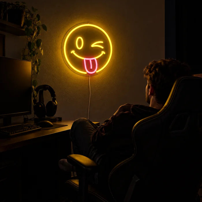 Frecher Smiley Neon LED Schild über dem Gaming-Schreibtisch, davor ein Spieler im Gaming-Stuhl