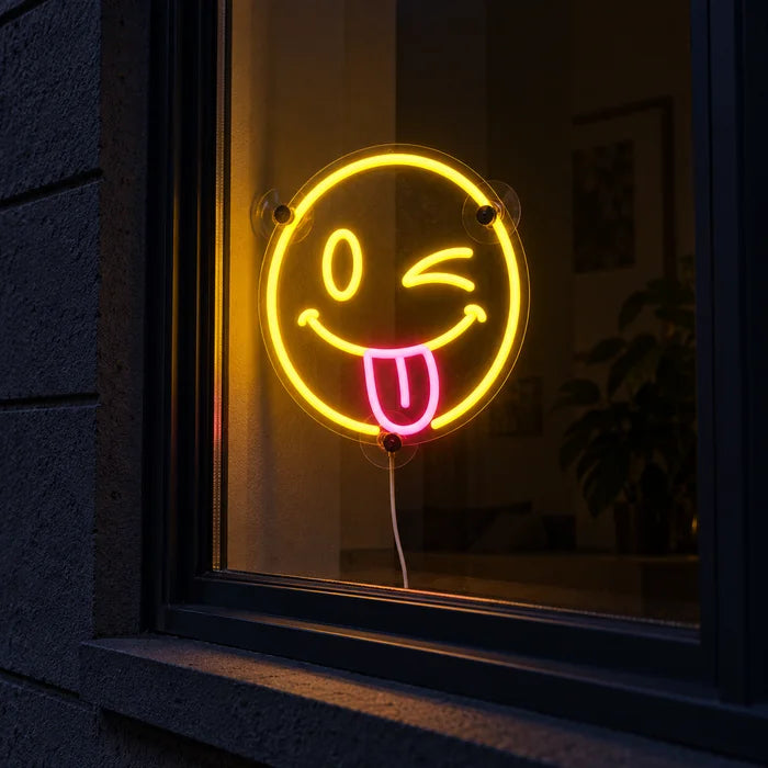 Frecher Smiley Neon LED Schild im Fenster, von der nächtlichen Straße aus gesehen