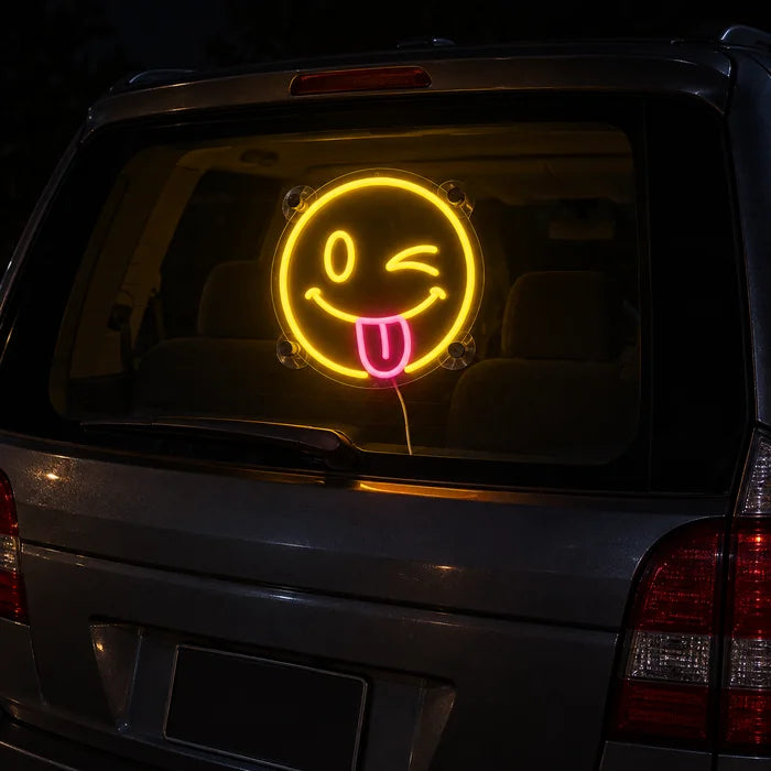 Frecher Smiley Neon LED Schild an der Heckscheibe eines Autos bei Nacht