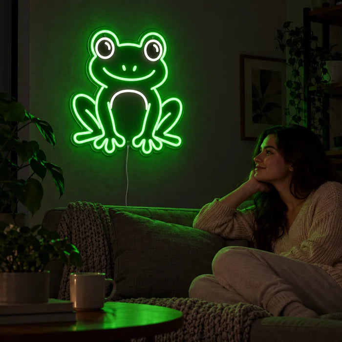 Froschfreund Neon LED Schild an der Wohnzimmerwand, davor entspannt eine Person auf dem Sofa