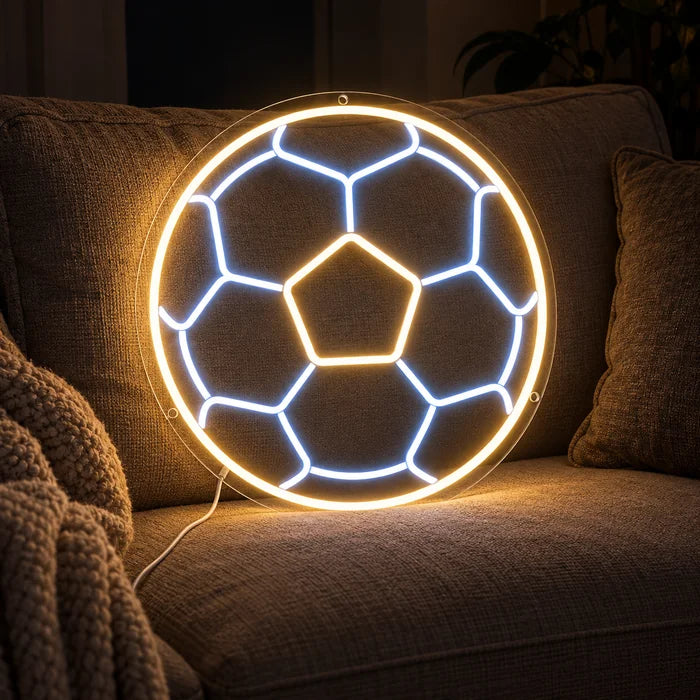 Fußball Neon LED Schild auf einem gemütlichen Sofa zwischen Kissen und Decke