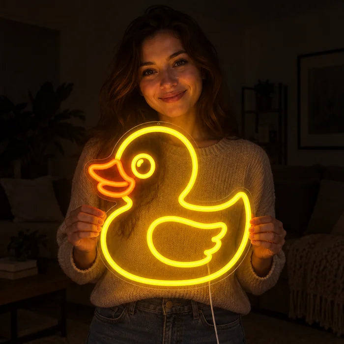 Gelbe Ente Neon LED Schild in den Händen einer lächelnden Frau vor dunklem Hintergrund