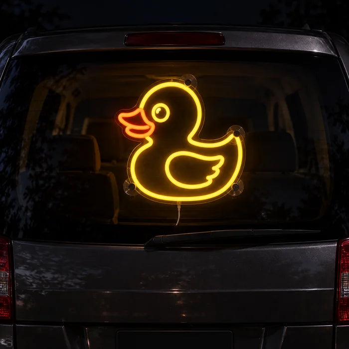 Gelbe Ente Neon LED Schild an der Heckscheibe eines Autos bei Nacht
