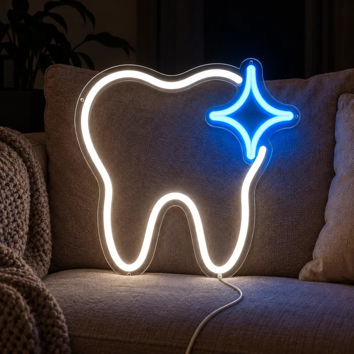 Glänzender Zahn Neon LED Schild auf einem gemütlichen Sofa zwischen Kissen und Decke