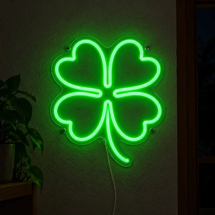 Glücksklee Neon LED Schild leuchtend an einer dunklen Wand, Nahaufnahme mit Anschlusskabel