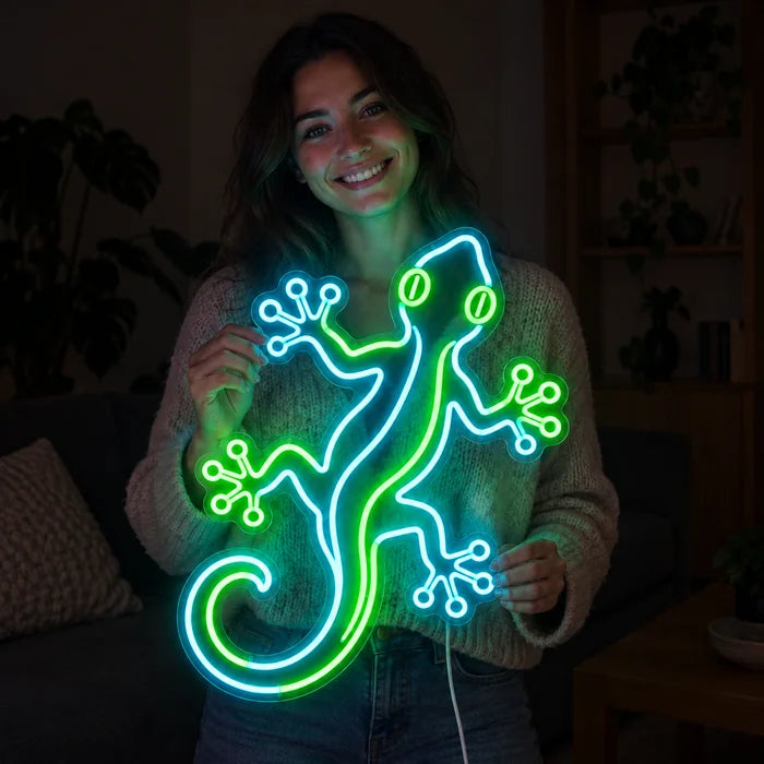 Grüner Gecko Neon LED Schild in den Händen einer lächelnden Frau vor dunklem Hintergrund