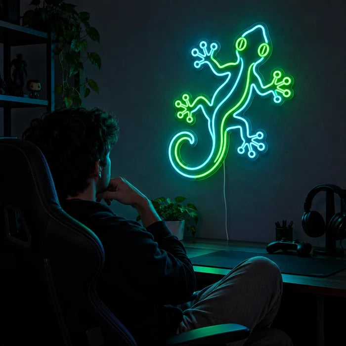 Grüner Gecko Neon LED Schild über dem Gaming-Schreibtisch, davor ein Spieler im Gaming-Stuhl