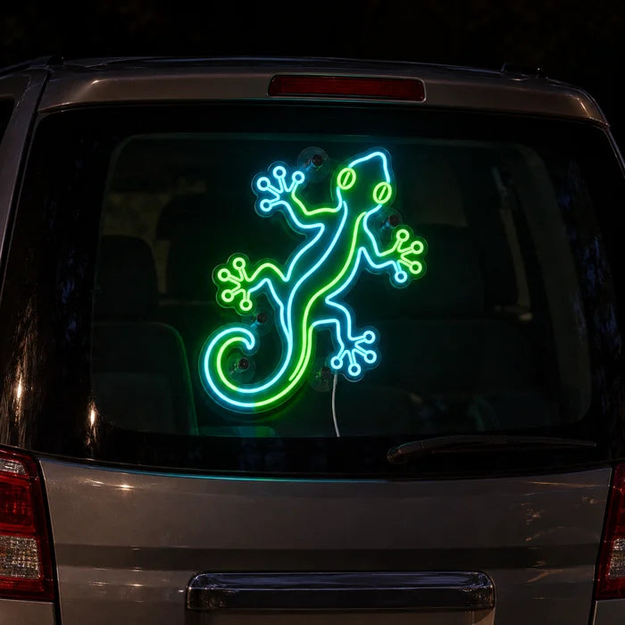 Grüner Gecko Neon LED Schild an der Heckscheibe eines Autos bei Nacht