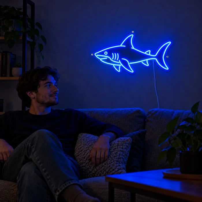 Hai Neon LED Schild an der Wohnzimmerwand, davor entspannt eine Person auf dem Sofa