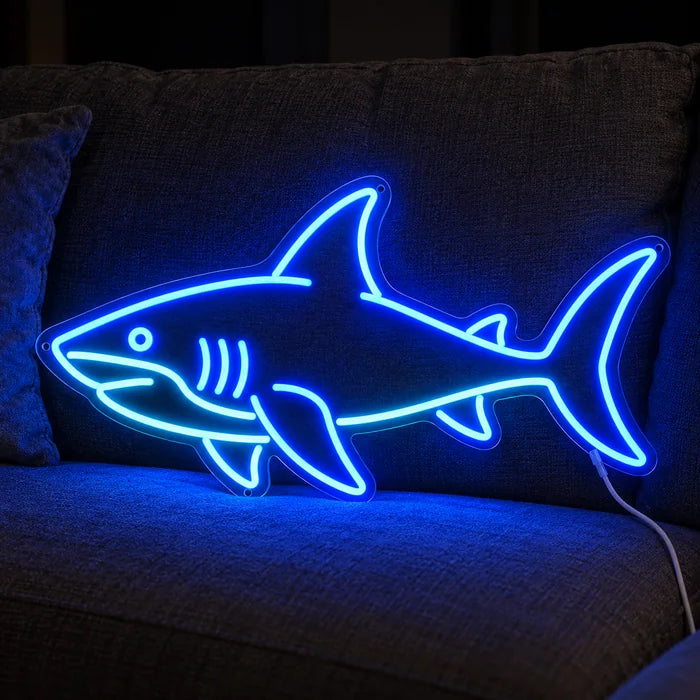 Hai Neon LED Schild auf einem gemütlichen Sofa zwischen Kissen und Decke