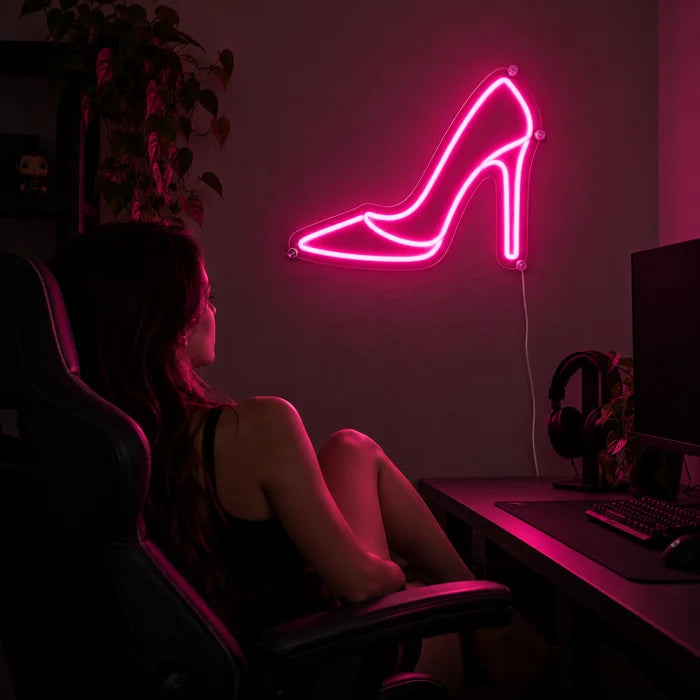 High Heel Neon LED Schild über dem Gaming-Schreibtisch, davor ein Spieler im Gaming-Stuhl