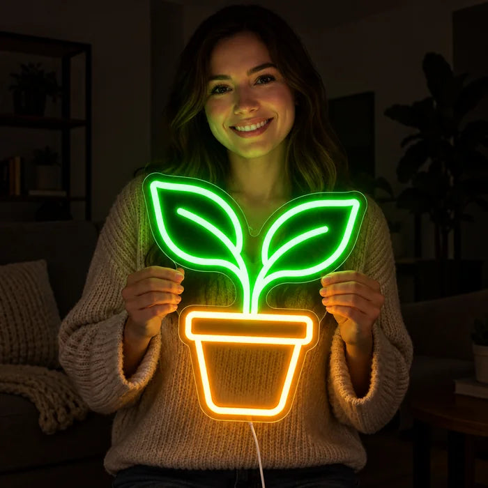 Kleiner Sprössling Neon LED Schild in den Händen einer lächelnden Frau vor dunklem Hintergrund