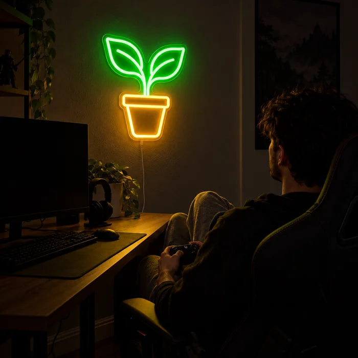 Kleiner Sprössling Neon LED Schild über dem Gaming-Schreibtisch, davor ein Spieler im Gaming-Stuhl