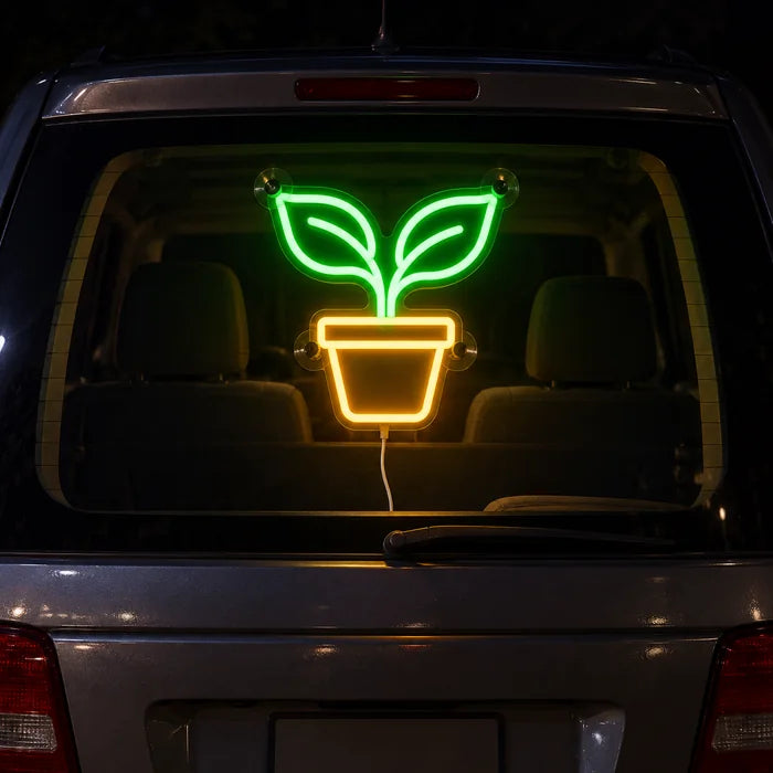 Kleiner Sprössling Neon LED Schild an der Heckscheibe eines Autos bei Nacht