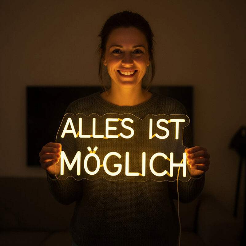 Modernes, individuelles Neon-Licht mit dem Text "ALLES IST MÖGLICH" als Wanddekoration auf dunklem Hintergrund.