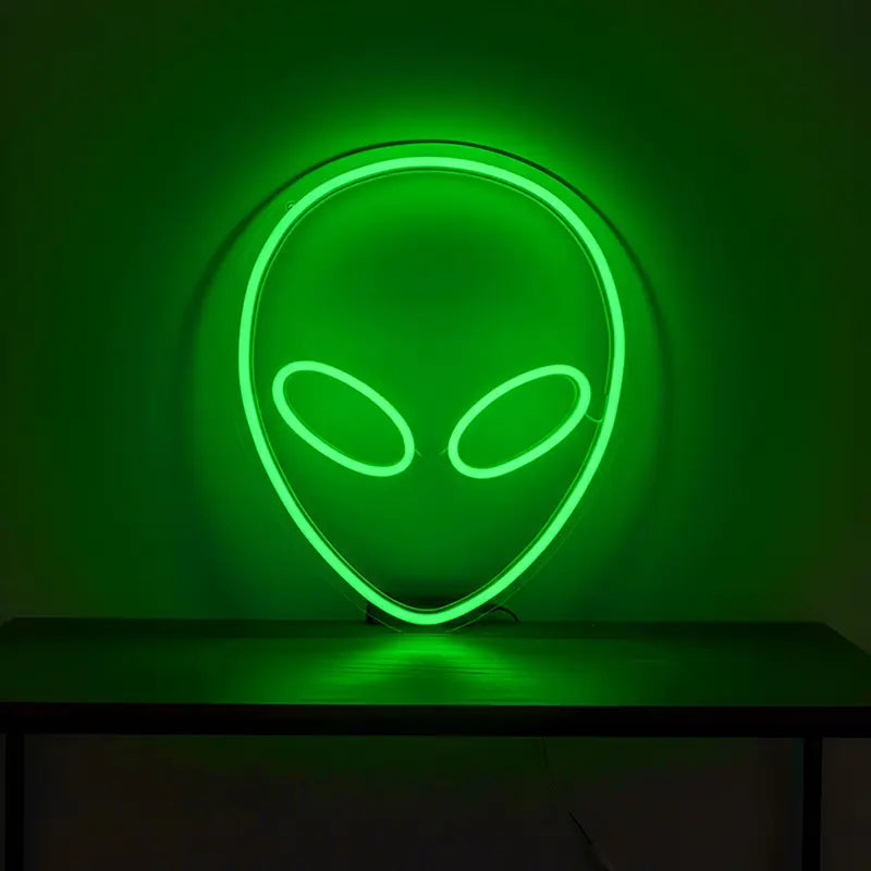 Custom-Neon-Sign mit dem Profil eines klassischen Aliens und einem leuchtenden, grünen Umriss.
