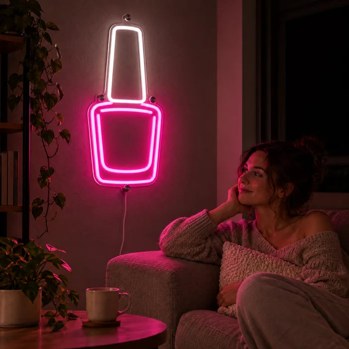 Nagellack Neon LED Schild an der Wohnzimmerwand, davor entspannt eine Person auf dem Sofa