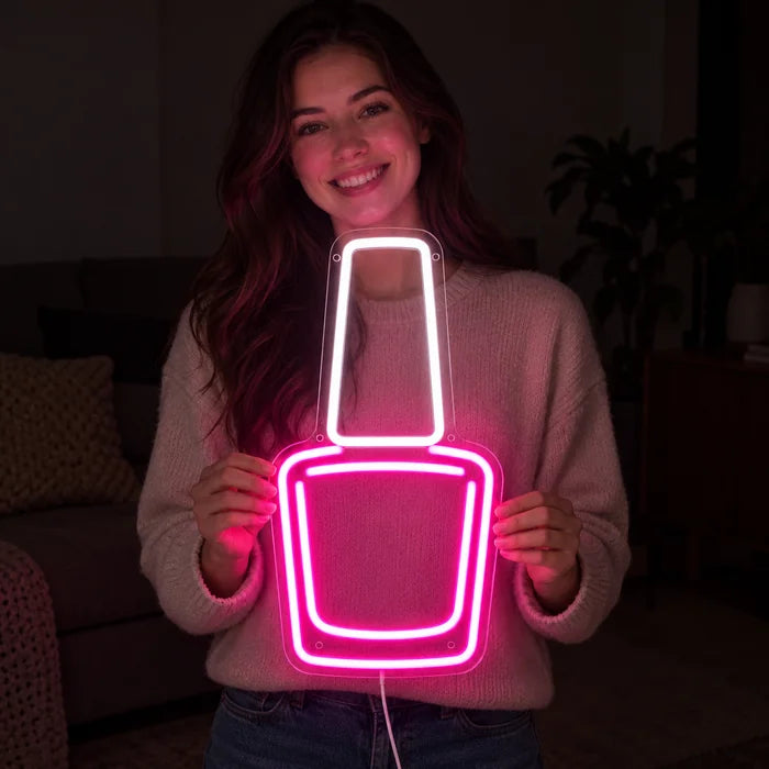 Nagellack Neon LED Schild in den Händen einer lächelnden Frau vor dunklem Hintergrund