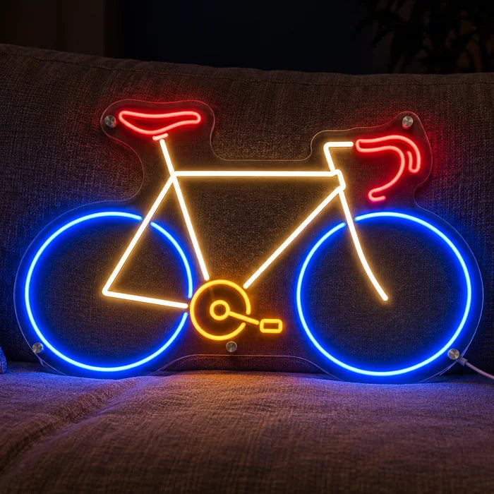 Neon-Rennrad Neon LED Schild auf einem gemütlichen Sofa zwischen Kissen und Decke