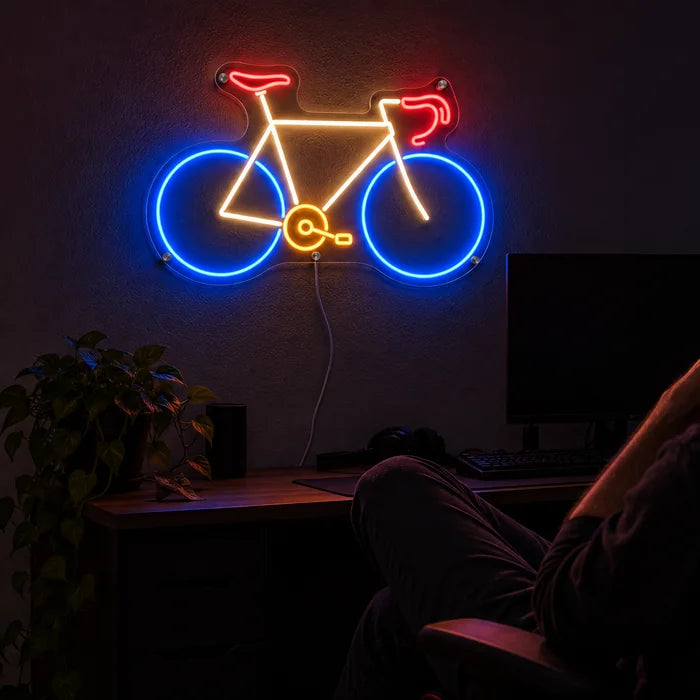 Neon-Rennrad Neon LED Schild über dem Gaming-Schreibtisch, davor ein Spieler im Gaming-Stuhl