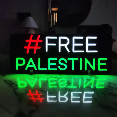 Neon-Schild mit dem Text "#FREE PALESTINE"; Hashtag in Rot, "FREE" in Weiß und "PALESTINE" in Grün.
