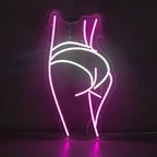 Neon-Schild als stilisierte, weibliche Silhouette in Pink und Weiß, die von hinten posiert.
