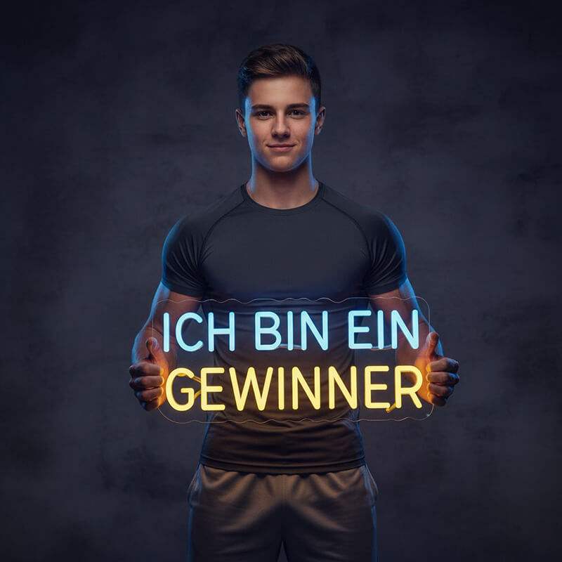 Zweizeiliges Neon-Schild mit dem deutschen Motivationsspruch "ICH BIN EIN GEWINNER", wobei "ICH BIN EIN" in Blau und "GEWINNER" in Gelb leuchtet.