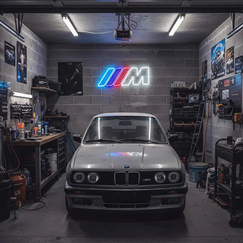 Nahaufnahme eines Neon-Lichts in Form des BMW M Logos, das auf einem Schrank steht und eine Wand im Hintergrund mit einem farbigen Schein beleuchtet