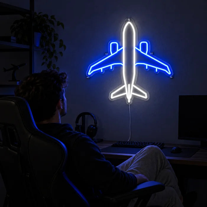 Passagierflugzeug Neon LED Schild über dem Gaming-Schreibtisch, davor ein Spieler im Gaming-Stuhl