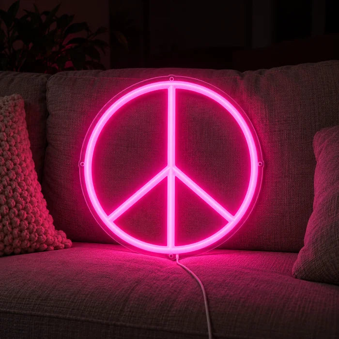 Peace Neon LED Schild auf einem gemütlichen Sofa zwischen Kissen und Decke